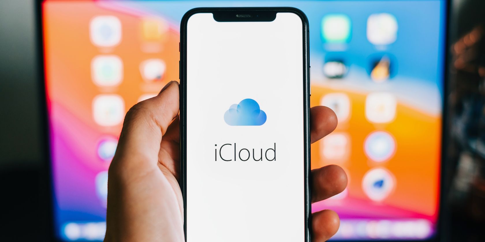 icloud on an iphone in front of a mac